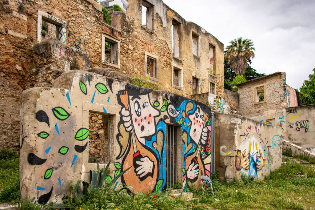 Musikanter på murvegg foran murhus i ruiner. Lisboa. Gatekunst. Fotografi