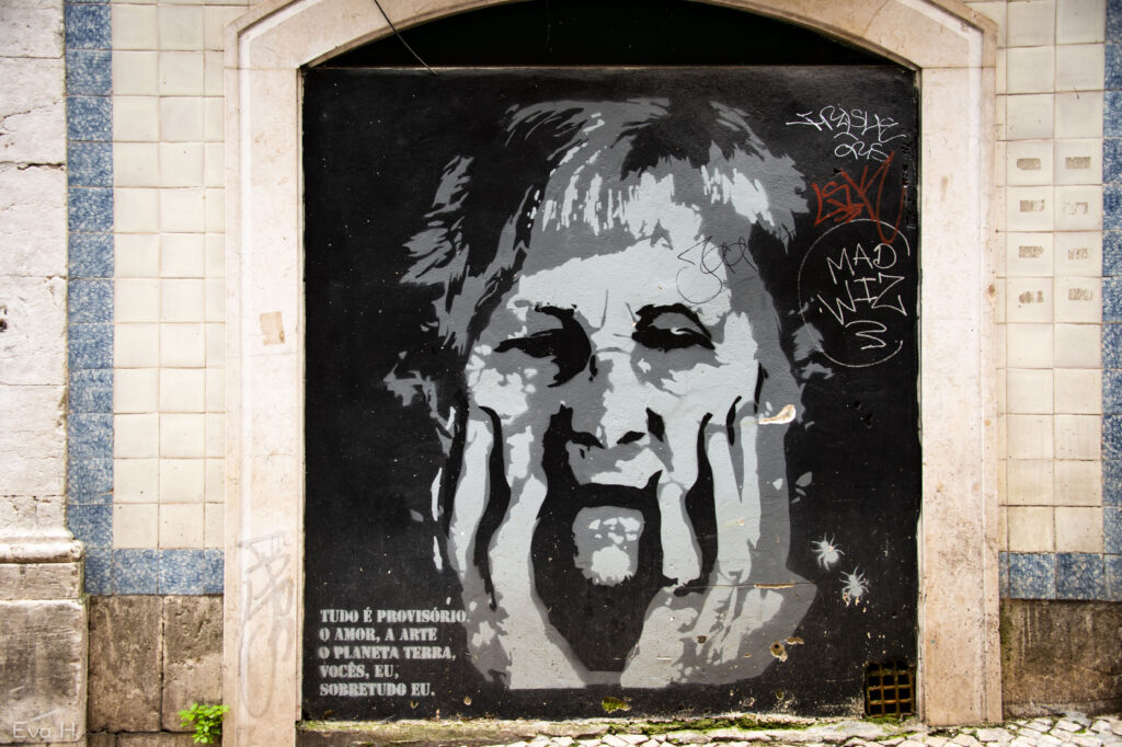 Sort/hvitt maleri på gjenmurt port. Eldre kvinne, bekymret. Gatekunst. Lisboa. Fotografi