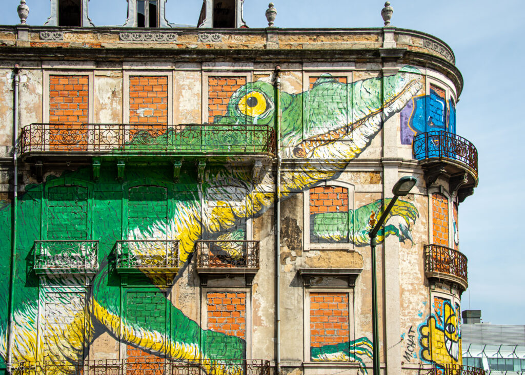 Fargerik krokodille malt over tre etasjer på kondemnert hus. Gatekunst. Lisboa. Fotografi